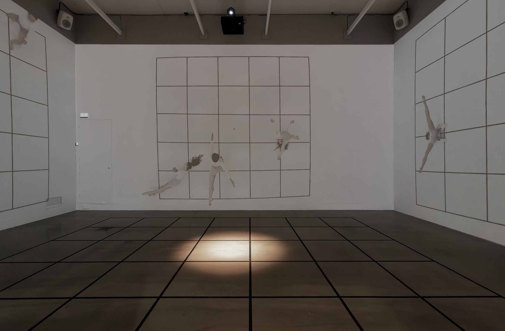 Three projected walls of dancers suspended on grids, with a lit grid on the floor