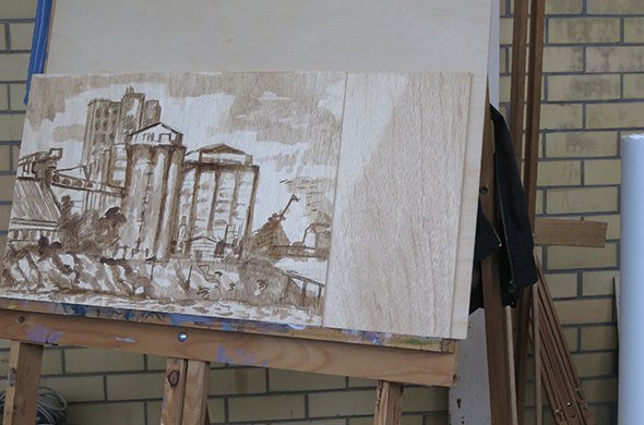 A painting of grain silos on an easel in the studio